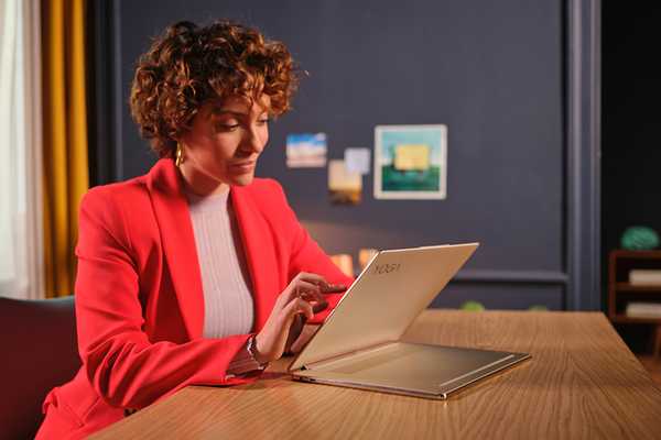 Woman smiling using a Lenovo Yoga Slim 7 Pro laptop.